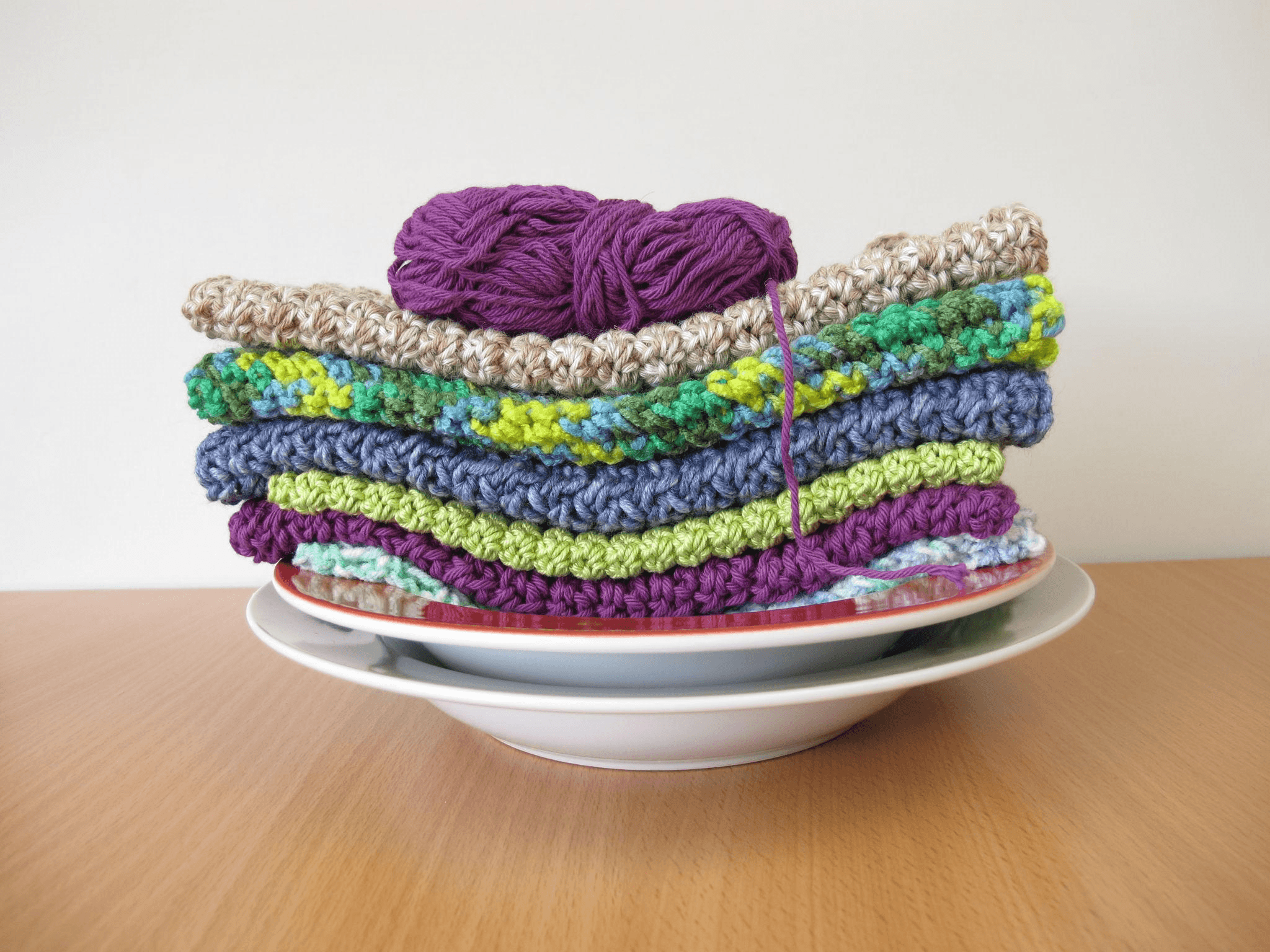 Stack of colorful hand-knitted dish cloths