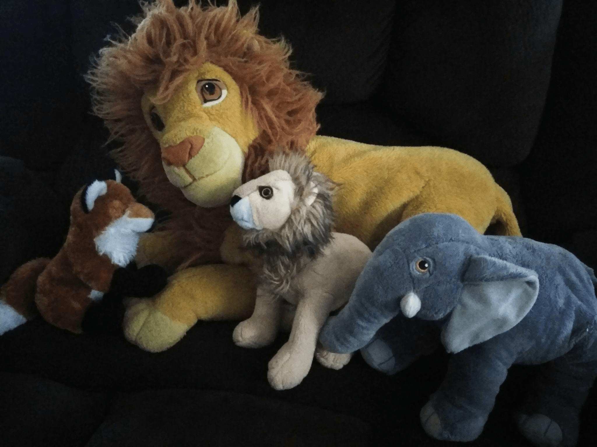 Assorted plush animal toys including lion, fox, and elephant